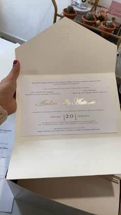 a person is holding up a wedding card