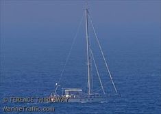 a sailboat floating in the ocean on a foggy day