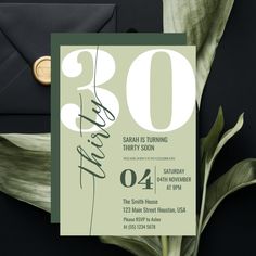 the 30th birthday party card is displayed next to an envelope and green leaves on a black background