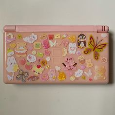 a pink children's laptop covered in lots of different stickers and magnets