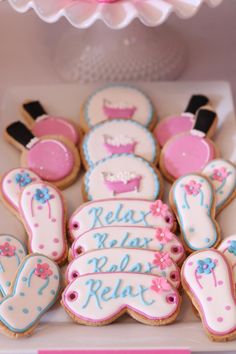 decorated cookies in the shape of ballet shoes are displayed on a table with pink and blue decorations