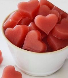 an apple cider vinegar gummies in a white bowl with hearts on the side