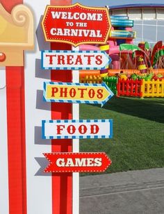 there are many signs on the pole in front of the carnival place sign that says, welcome to the carnival treats photos food games