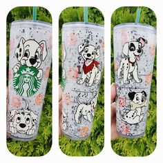 the starbucks cup is decorated with dogs on it and has two straws in front of it