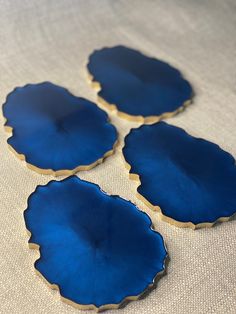 three blue plates sitting on top of a white cloth covered table next to each other