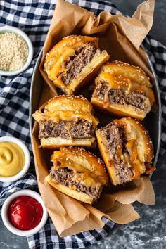 cheeseburger sliders with mustard and ketchup in a basket on a checkered tablecloth