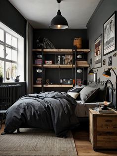 a bedroom with black walls and wooden floors, an open book shelf on the far wall