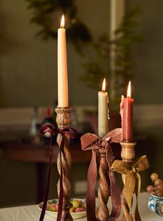 two candles are sitting on a table with other decorations