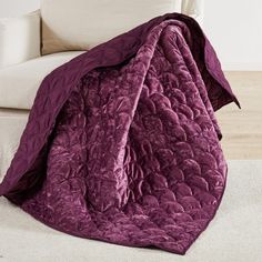 a couch with a purple blanket on top of it