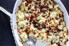 a casserole dish with bacon and cheese in it on a blue tablecloth