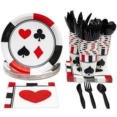 a table set with black and red playing cards on plates, forks and napkins