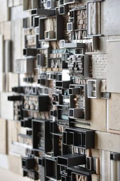 a wall made up of different types of square and rectangle shaped metal objects on it's sides