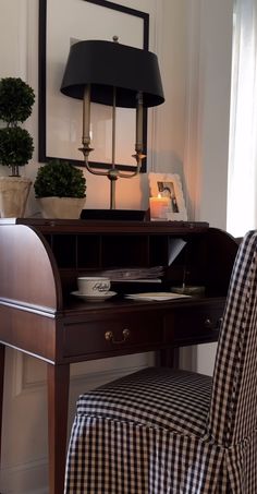 a desk with a lamp and chair in front of it