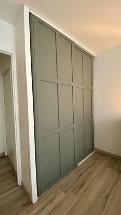 an empty room with sliding doors and hard wood flooring on the side of the wall