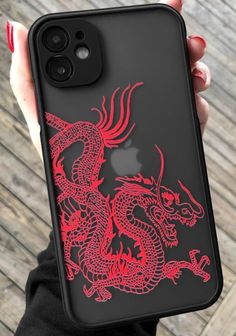 a woman holding an iphone case with a red dragon on it