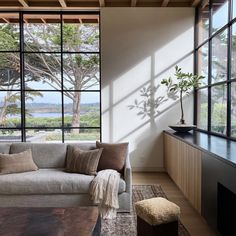 a living room filled with furniture and large windows