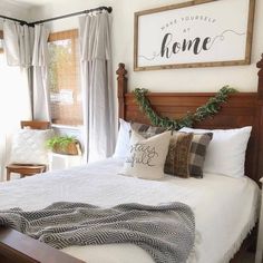 a bed with pillows and blankets on top of it next to a wooden headboard