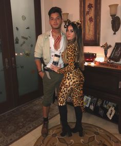 a man standing next to a woman in a leopard print dress