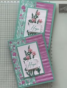 two cards with flowers on them sitting next to a ruler and some paper cuttings