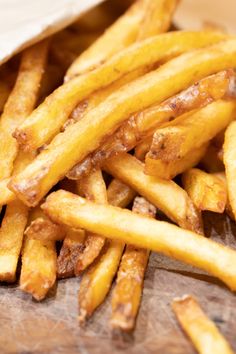 french fries are sitting on a cutting board