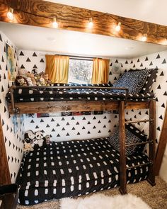 a bunk bed sitting in the corner of a room with black and white wallpaper