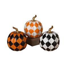 three pumpkins with black and white checkered designs are sitting next to each other