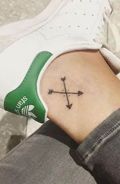 a person with a small tattoo on their left arm and an arrow in the middle