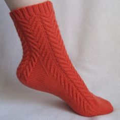 a woman's legs wearing red socks with cabled design on the bottom and sides