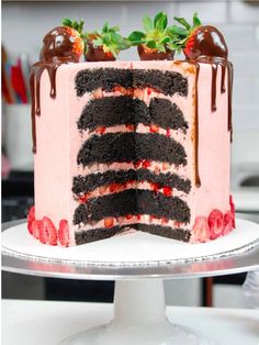 a cake with chocolate and strawberry toppings on top is shown in the foreground