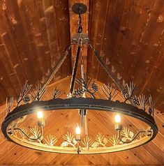 a chandelier hanging from the ceiling with pine cones and leaves on it's sides