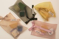 four different types of organine bags with ribbons and tags attached to the handles on them