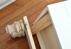 a close up of a drawer on the floor next to a wooden door handle and cabinet