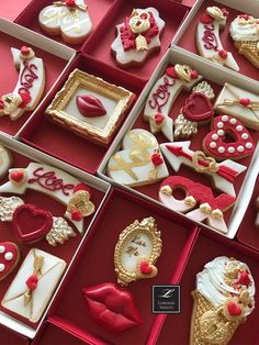 many decorated cookies in red boxes with white and gold trimmings on the edges