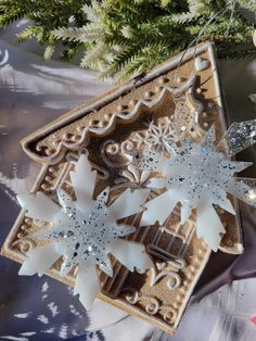 two snowflakes are hanging from a christmas tree