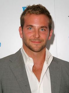 a man in a gray suit and white shirt posing for the camera at an event