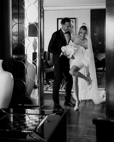 a bride and groom are posing for a photo in the hotel room, black and white