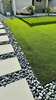 a lawn with stones and grass in front of a house