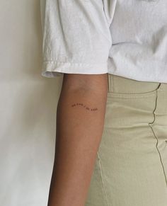 a woman with a small tattoo on her left arm and the word love is written in cursive writing