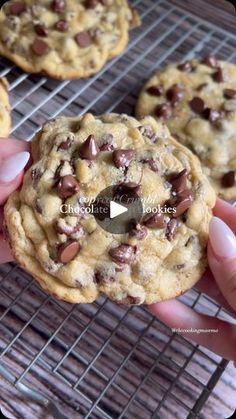 chocolate chip cookies on a cooling rack being held up by someone's right hand