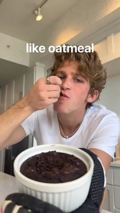 a young man is eating chocolate cake with the caption like oatmeal