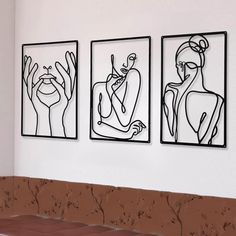 three black and white paintings hanging on the wall above a bench in front of a couch