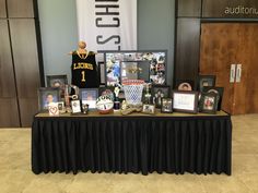 a table topped with pictures and memorabilia next to a basketball jersey