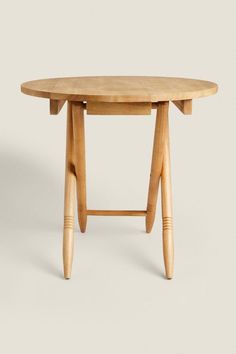 an oval wooden table with two legs and a circular top, on a white background