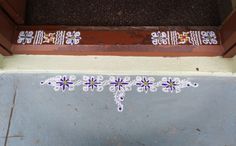 some stickers are painted on the side of a building and it is white with purple flowers