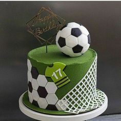 a soccer themed birthday cake with a soccer ball on top