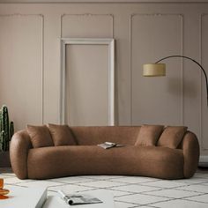 a living room with a couch, table and potted plant on the floor in front of it