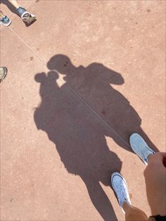 the shadow of two people standing next to each other with their shadows on the ground