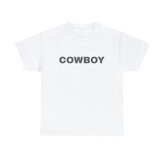 "Introducing our \"Cowboy\" t-shirt, a rugged and stylish addition to your wardrobe that captures the spirit of the Wild West. This t-shirt celebrates the timeless appeal of cowboy culture with its bold \"Cowboy\" print. Whether you're a true country enthusiast or simply admire the adventurous cowboy lifestyle, this tee is designed to make a statement. Made from comfortable and durable fabric, it's perfect for both casual outings and rodeo-ready looks. Embrace your inner cowboy or cowgirl and show off your love for all things Western with this classic \"Cowboy\" t-shirt. Saddle up and make it your go-to choice for a touch of frontier flair in your everyday style! The unisex heavy cotton tee is the basic staple of any wardrobe. It is the foundation upon which casual fashion grows. All it ne Western Style Cotton T-shirt For Rodeo, White Western T-shirt For Rodeo, White Graphic Tee For Western-themed Events, White Graphic Print T-shirt For Western-themed Events, Casual White T-shirt For Western-themed Events, White Crew Neck Tops For Western-themed Events, White Letter Print T-shirt For Ranch, White Crew Neck T-shirt For Rodeo, White Graphic Print Shirt For Rodeo