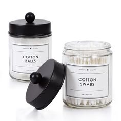 two jars with cotton swabs in them next to each other on a white surface