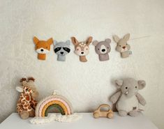 several stuffed animals are hanging on the wall next to a toy car and teddy bear